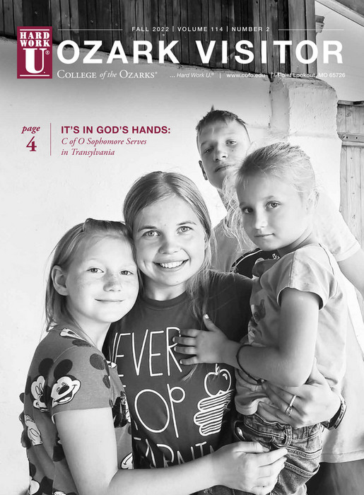 Cover for the Fall 2022 Ozark Visitor magazine issue, a College of the Ozarks student posing with children in Transylvania.