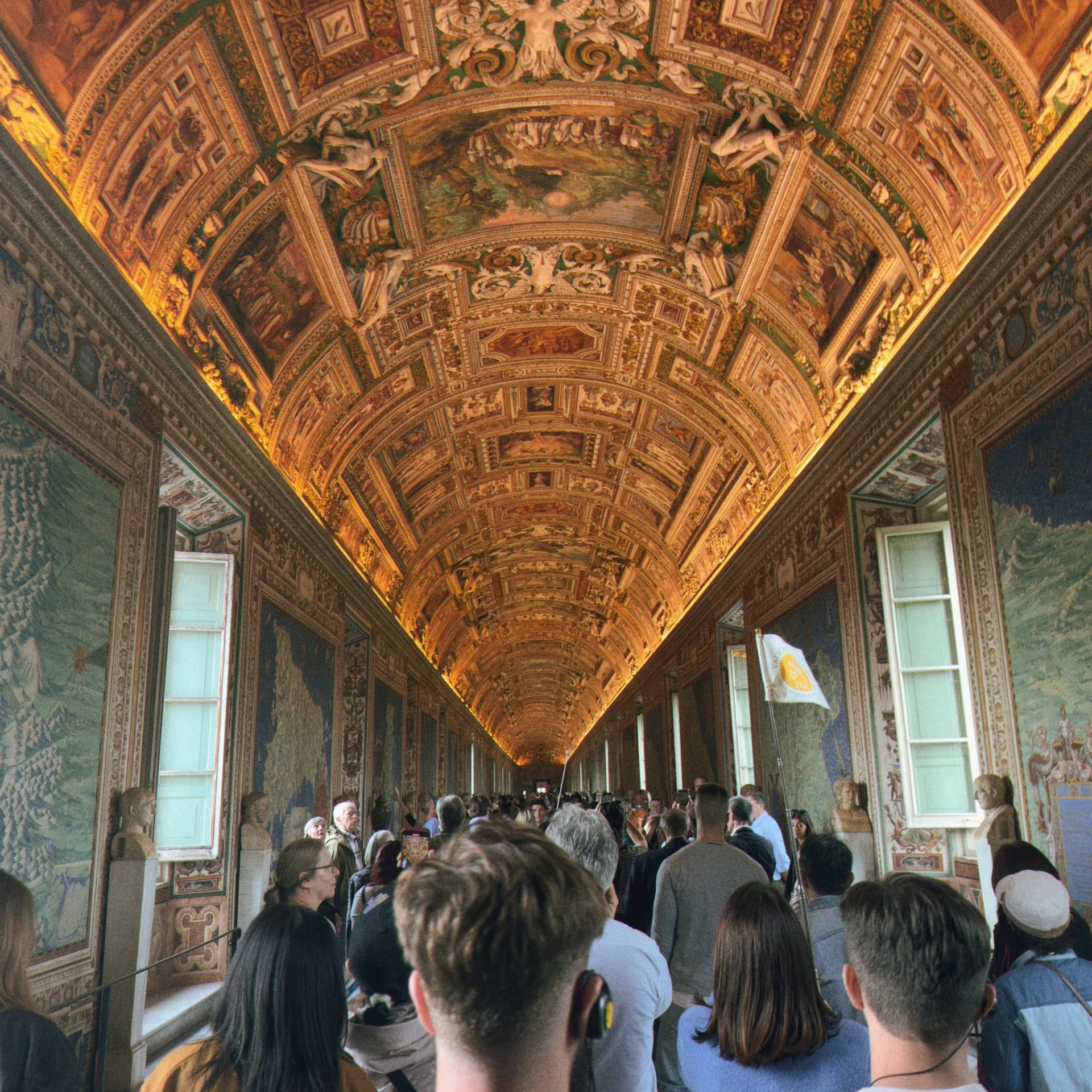 a group of people walking down a long hallway