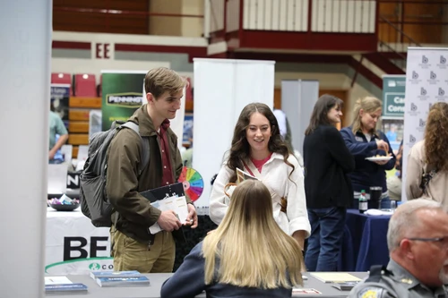Students networking with a potential employer 