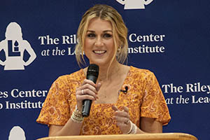 Riley Gaines speaks at podium. 