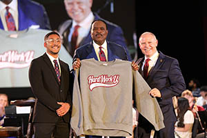 James Brown holds a Hard Work U sweatshirt.