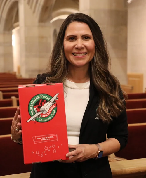 Izabella McMillon holding an Operation Christmas Child Shoebox