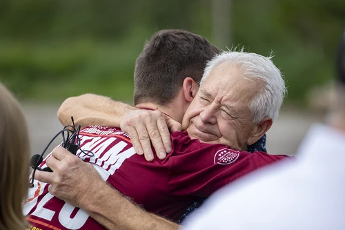 Veteran and student hugging