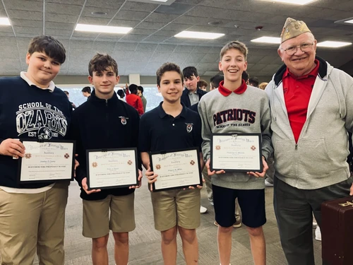 Boys and veteran smiling with awards