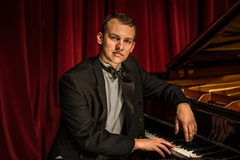 Man sitting near a piano