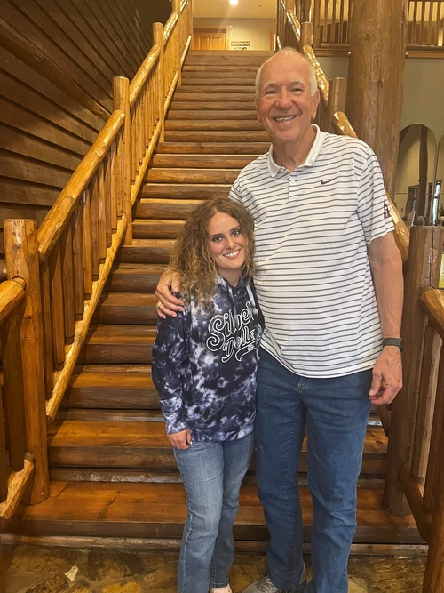A tall man is standing next to a female student in the lodge area of the Keeter Center. 