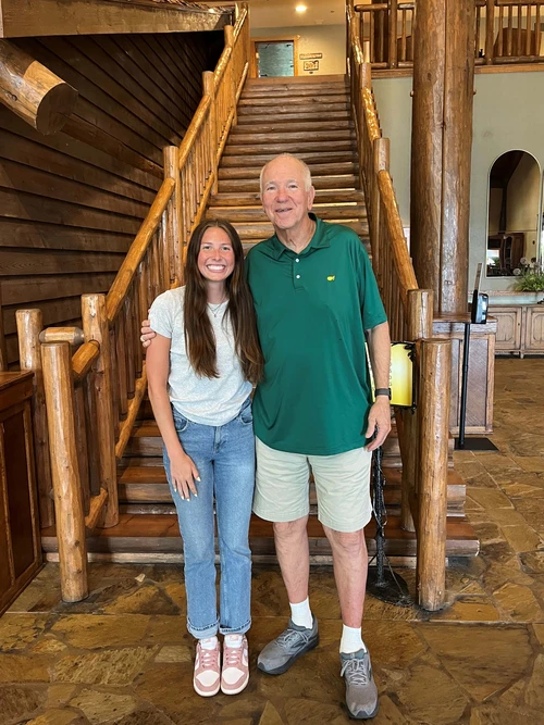 A female student is standing next to a tall man in the lodge area at the Keeter Center