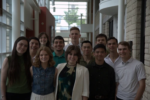 A group of twelve students posing for a picture.