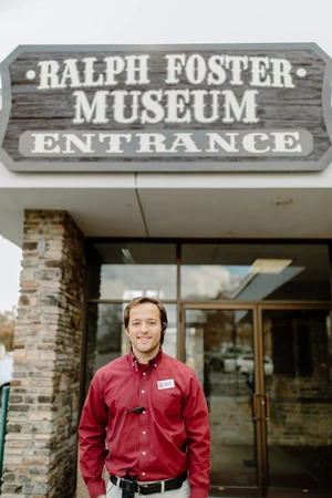 A young man standing in front of a building.
