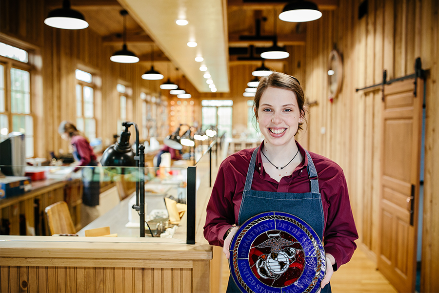Stained glass student worker presenting a stained glass project