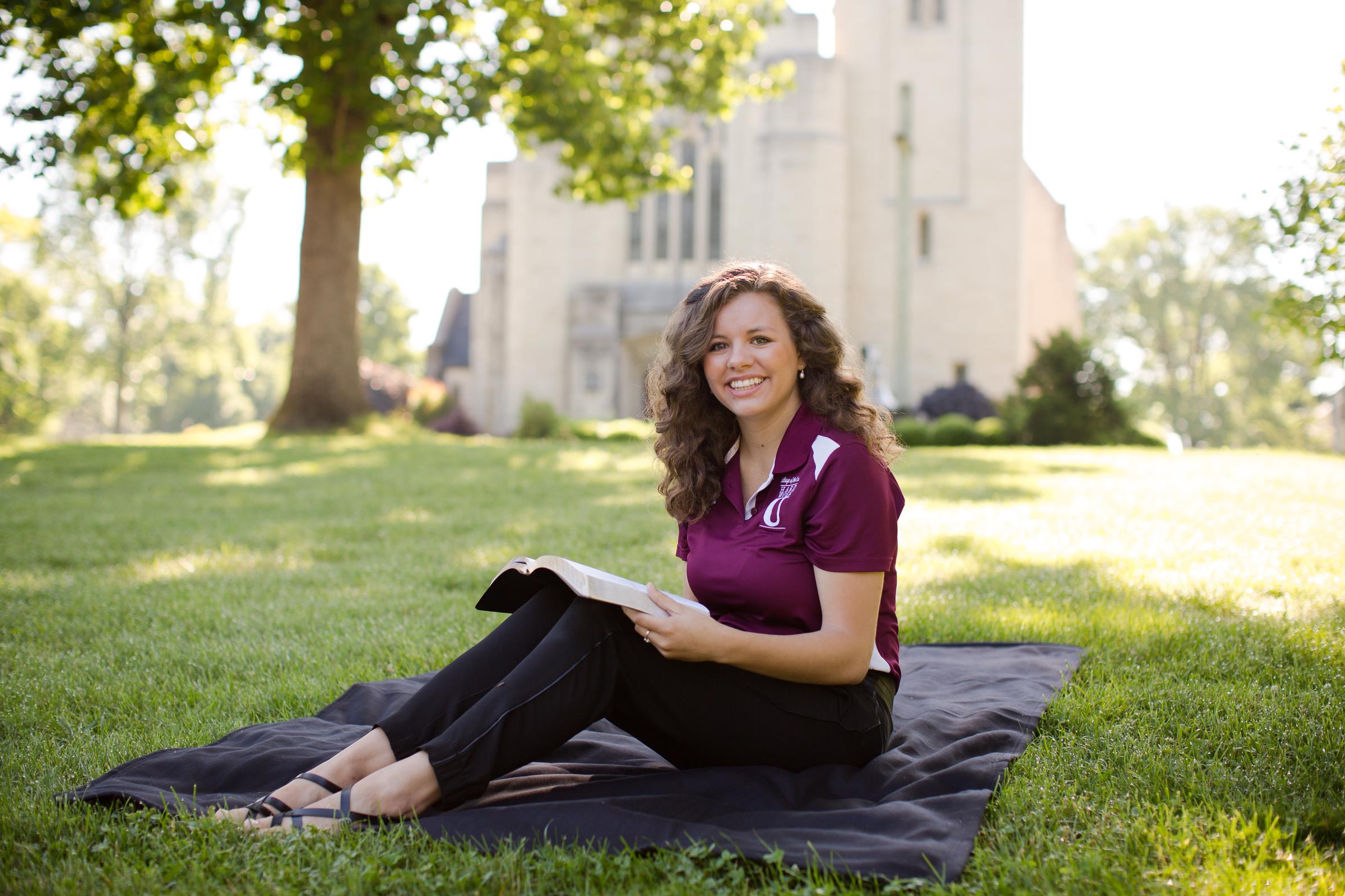 Student reading a book outside