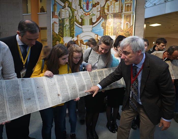 Man reading INSPIRED exhibit scroll.