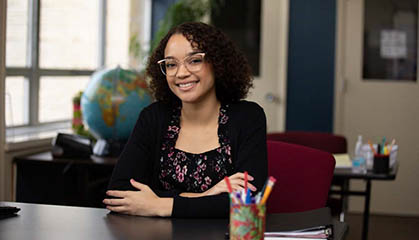 Student smiling setting at a desk