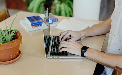 Hands typing on a laptop.