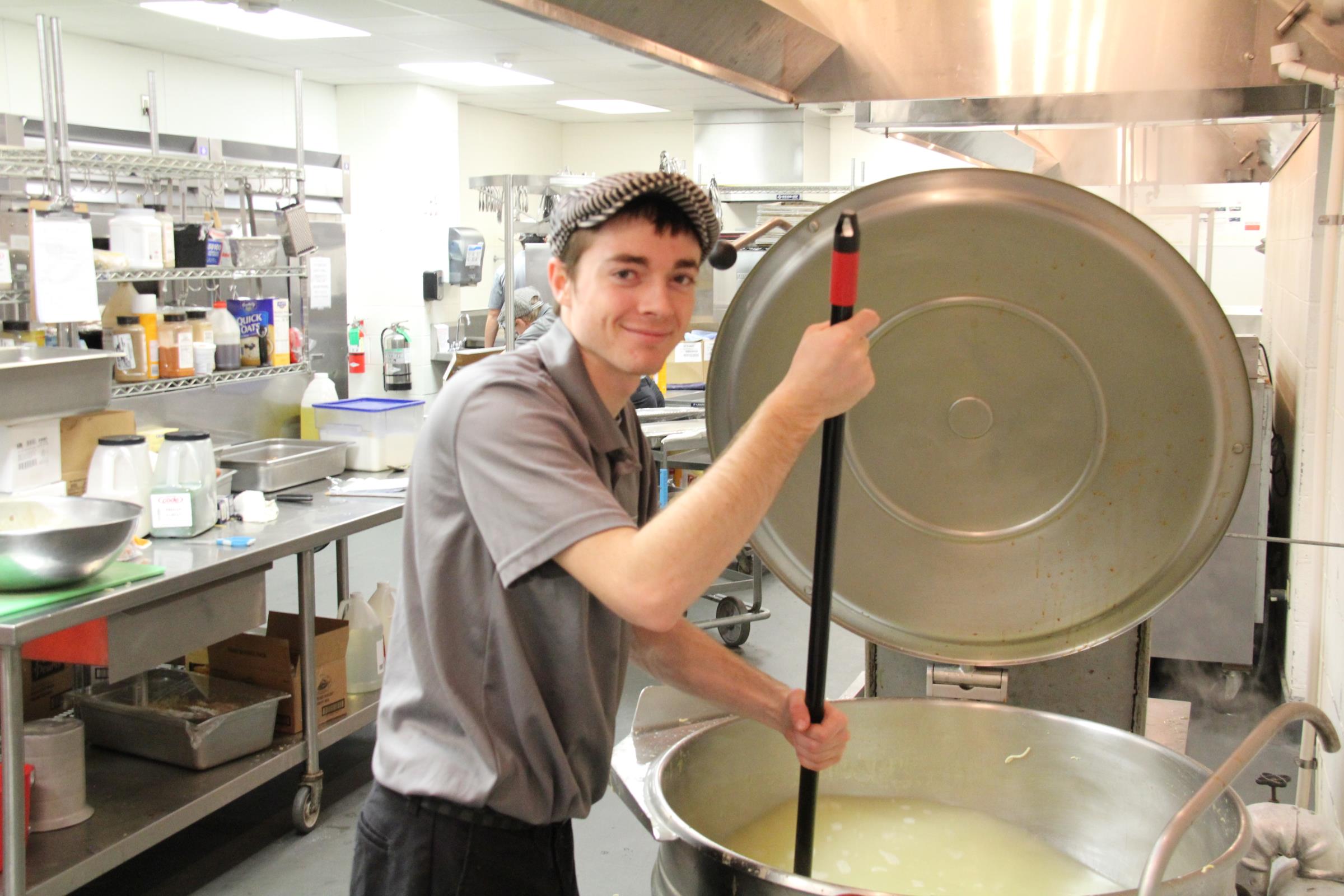 Student worker making soup in the Pearl Rogers Cafeteria