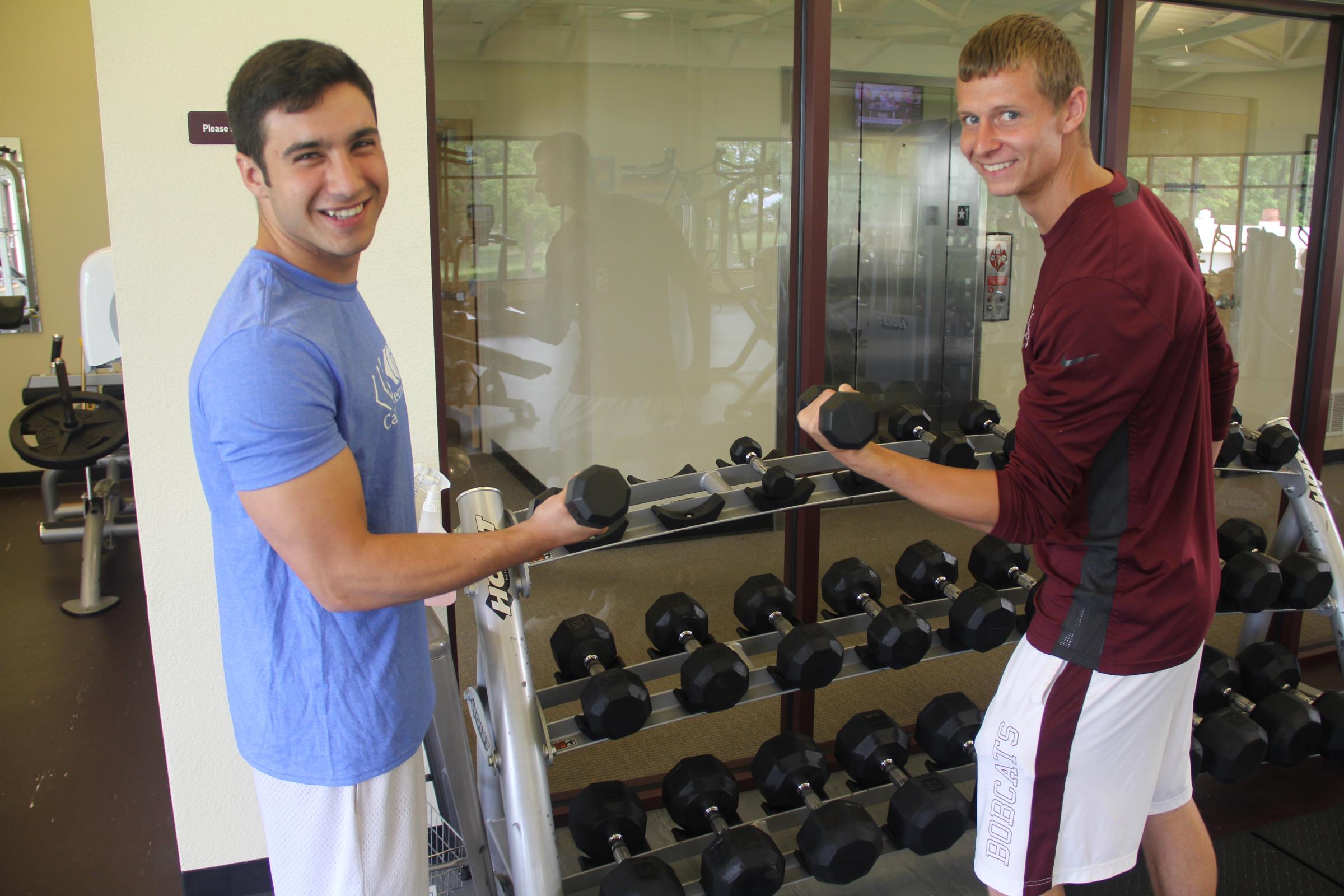 Two students lifting weights