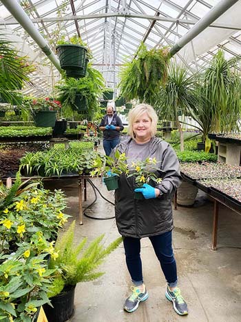 Pamela Spears, administrative assistant and event coordinator for The Keeter Center for Character Education, volunteers to work in landscaping for a day, assisting greenhouse manager Nathan Bell. Normally, more than 15,000 seedlings must be planted each week in order to be ready for spring.