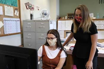 Junior Stacy Roberts, marketing major, and junior Celine Douthit, public relations major, review a document in the administrative offices during the Summer Work Education Program in June.