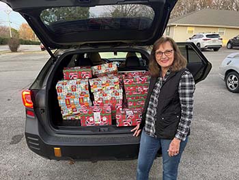 Mrs. Davis drops off the brightly colored Operation Christmas Child boxes.